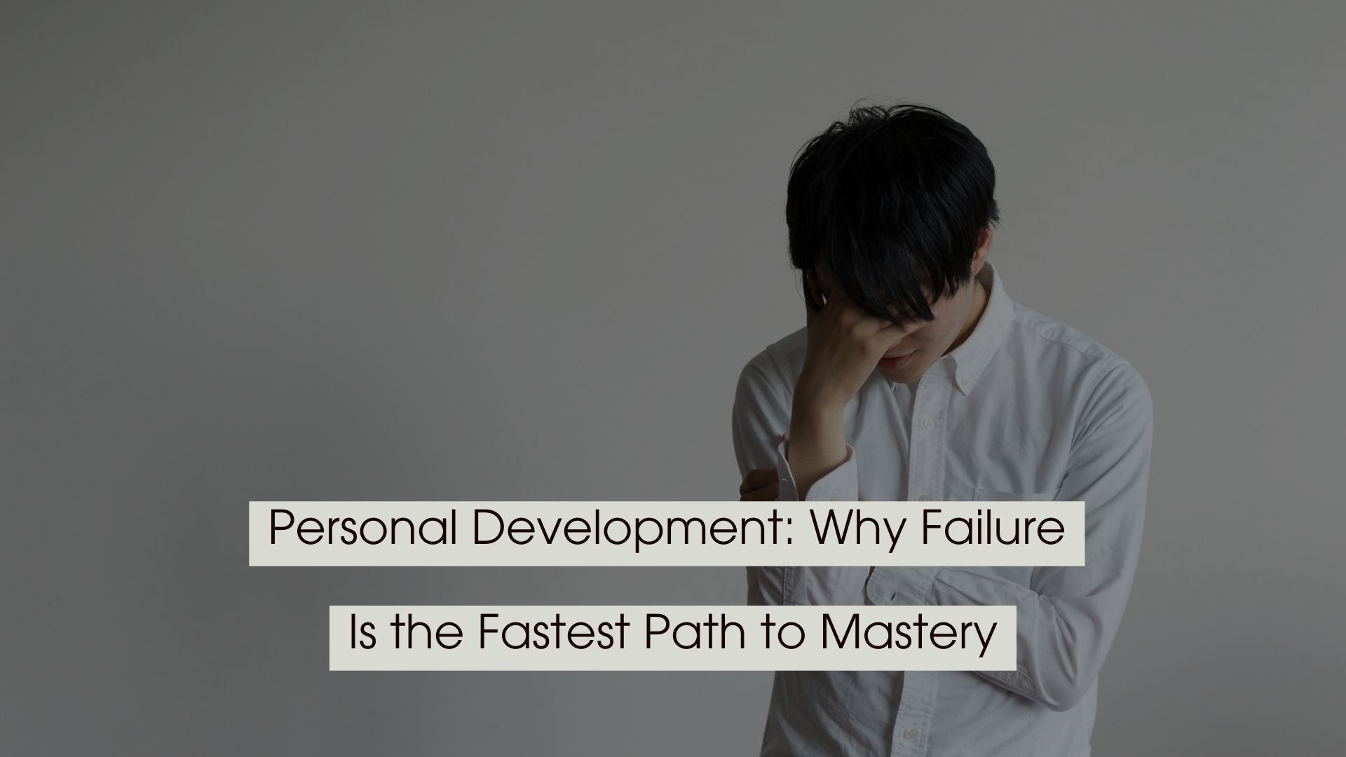 Young man in a white shirt looking down with his hand on his forehead, appearing frustrated or reflective, with the text “Personal Development: Why Failure Is the Fastest Path to Mastery” displayed across the image.