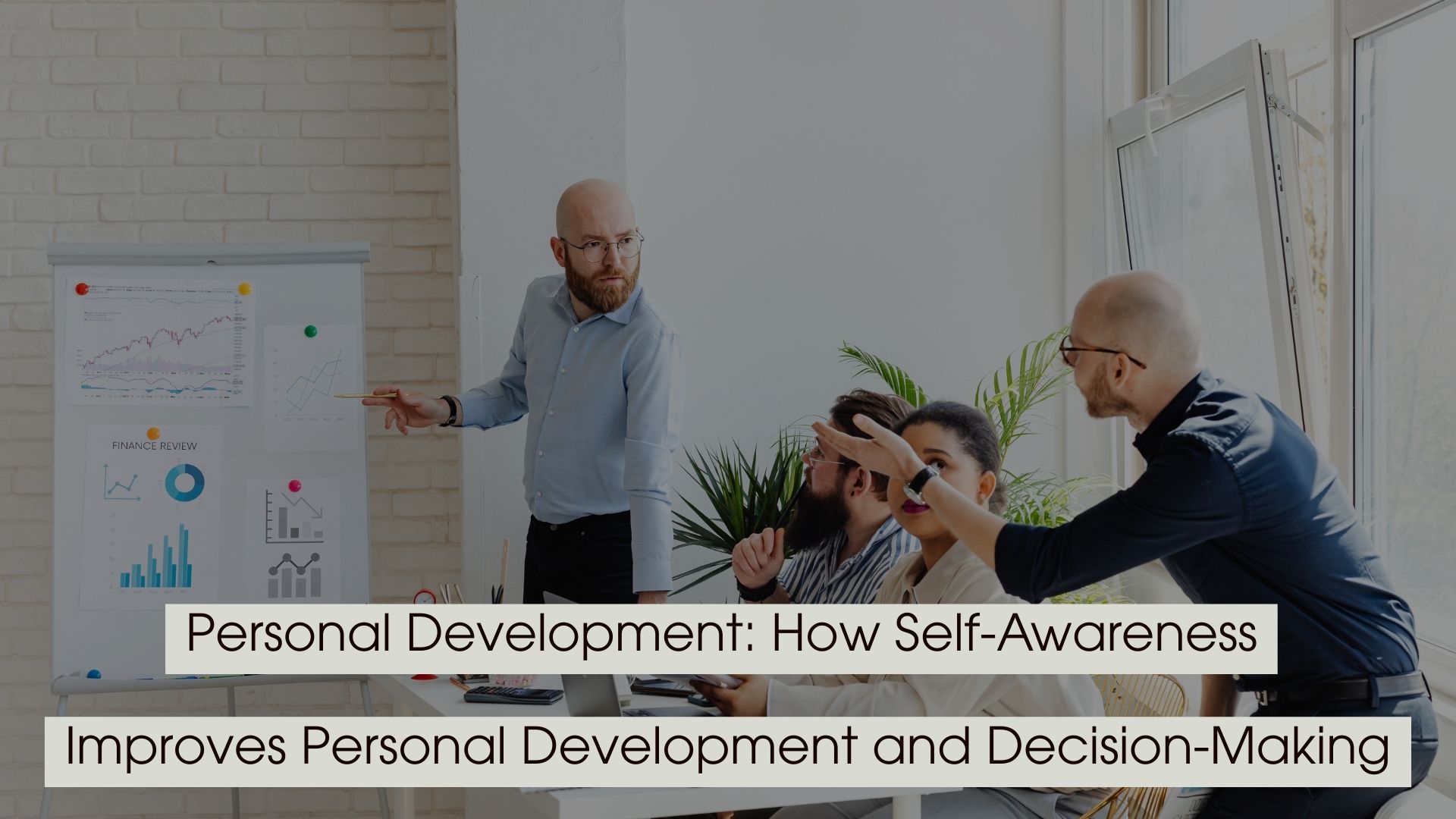 Team meeting with a presenter pointing at charts on a board while colleagues engage in discussion, with the text “Personal Development: How Self-Awareness Improves Personal Development and Decision-Making” displayed across the image.