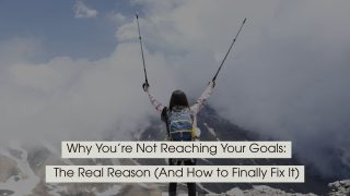 Hiker standing on a mountain summit with arms raised in victory, symbolizing achievement and overcoming challenges, with the text “Why You’re Not Reaching Your Goals: The Real Reason (And How to Finally Fix It)” displayed across the image.