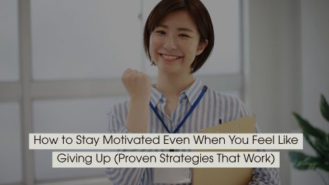 Smiling person holding a clipboard and raising a fist in a gesture of determination, symbolizing motivation and perseverance, with the text “How to Stay Motivated Even When You Feel Like Giving Up (Proven Strategies That Work)” displayed across the image.