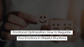 Person holding wooden emotion blocks showing a smiling and sad face, representing emotional optimization and how to regulate emotions during stressful situations.