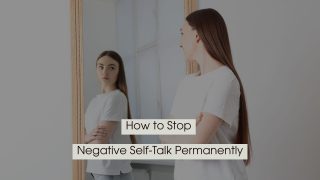 Young woman standing with arms crossed while looking at her reflection in a mirror, with the text “How to Stop Negative Self-Talk Permanently” displayed across the image.