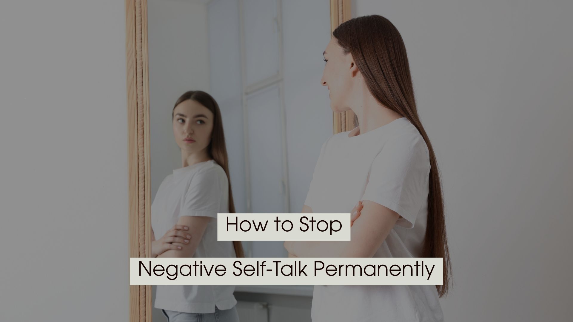 Young woman standing with arms crossed while looking at her reflection in a mirror, with the text “How to Stop Negative Self-Talk Permanently” displayed across the image.