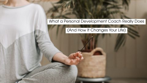 Person sitting cross-legged in a calm indoor setting, holding an incense stick during a mindfulness practice, symbolizing personal development coaching, self-awareness, and inner growth.