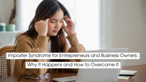 Entrepreneur sitting at a desk with a laptop, holding her temples in frustration, illustrating imposter syndrome, self-doubt, and mental overwhelm experienced by business owners.