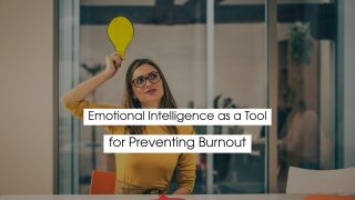 Person holding a lightbulb cutout above their head, symbolizing emotional intelligence as a tool for preventing burnout, creativity, self-awareness, and stress management in a modern workspace.