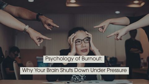 Stressed woman sitting at a desk with hands on her head while several hands point fingers at her, with the text “Psychology of Burnout: Why Your Brain Shuts Down Under Pressure” displayed across the image.