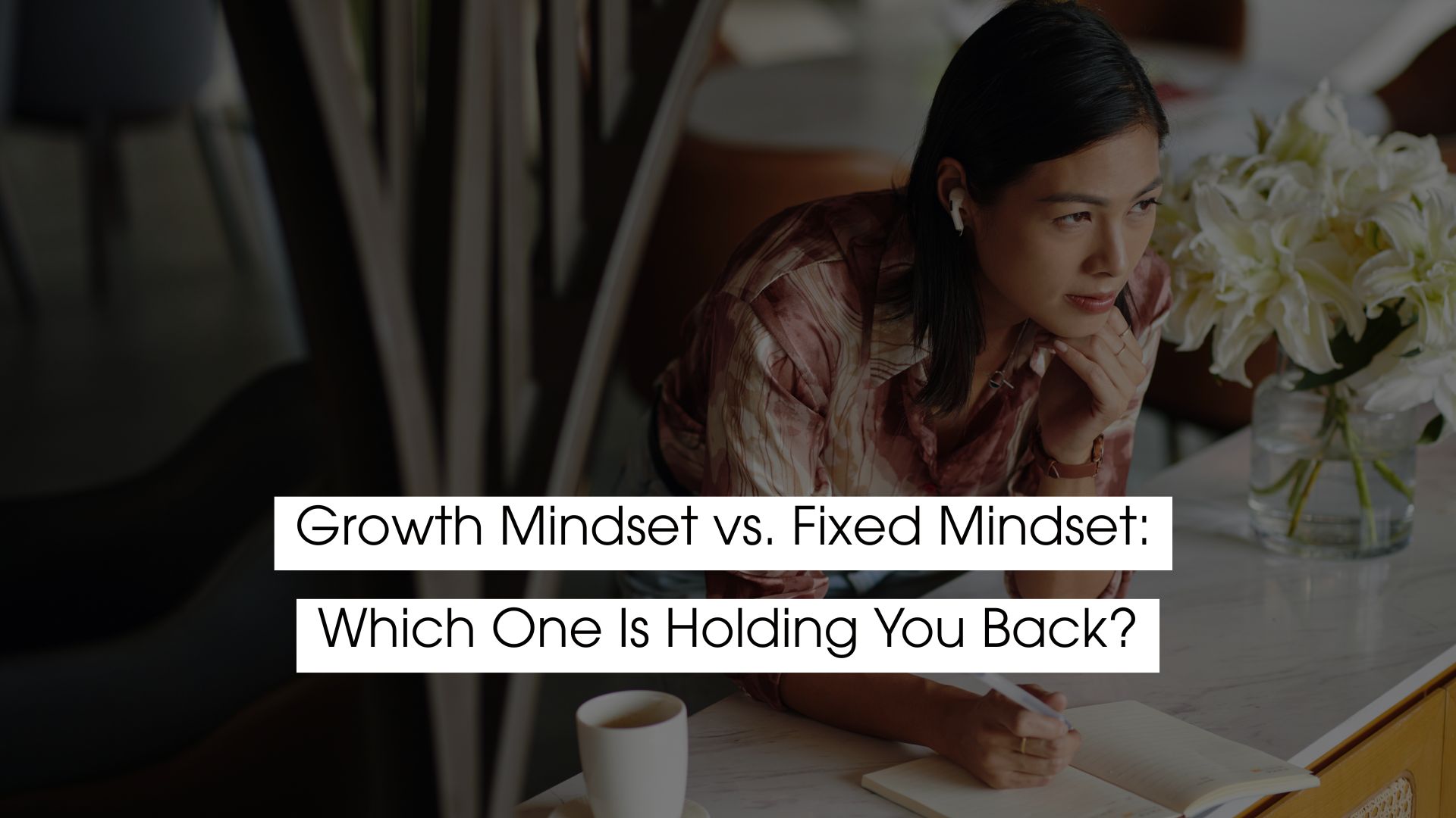 Person reflecting and journaling at a table, illustrating the concept of growth mindset vs. fixed mindset and how mindset patterns can either support or limit personal development and self-improvement.
