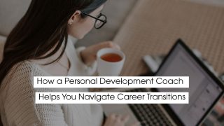 Woman holding a cup of tea while working on a laptop at home, representing how a personal development coach helps individuals navigate career transitions with clarity and confidence.