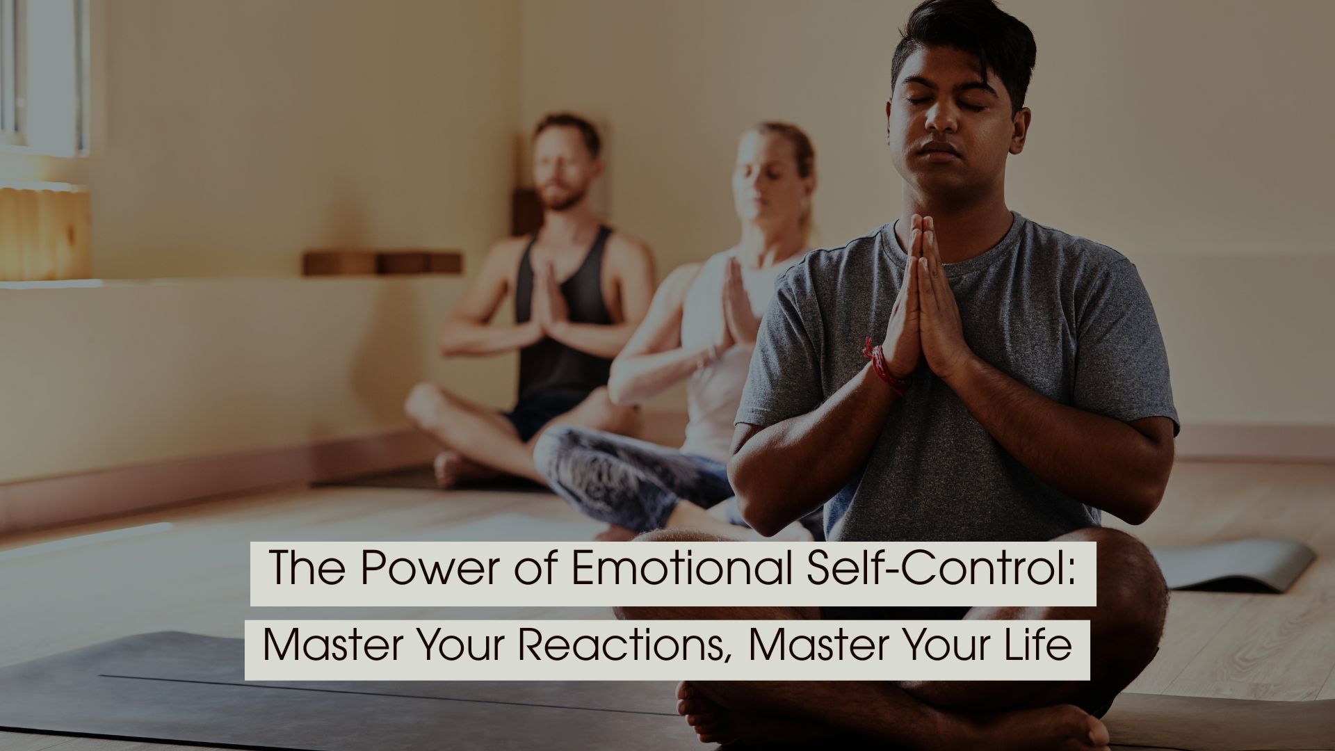 A group of people sitting cross-legged in a yoga studio with eyes closed and hands in a prayer position, practicing meditation and emotional control, with the text “The Power of Emotional Self-Control: Master Your Reactions, Master Your Life” displayed across the image.