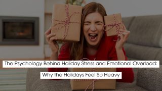 A woman sitting on the floor, holding two gift boxes with red ribbons, looking overwhelmed and stressed. She is wearing a red sweater, with a frustrated expression on her face, possibly due to holiday-related pressure. The image has a cozy indoor setting with a fireplace in the background. The text on the image reads: "The Psychology Behind Holiday Stress and Emotional Overload: Why the Holidays Feel So Heavy."
