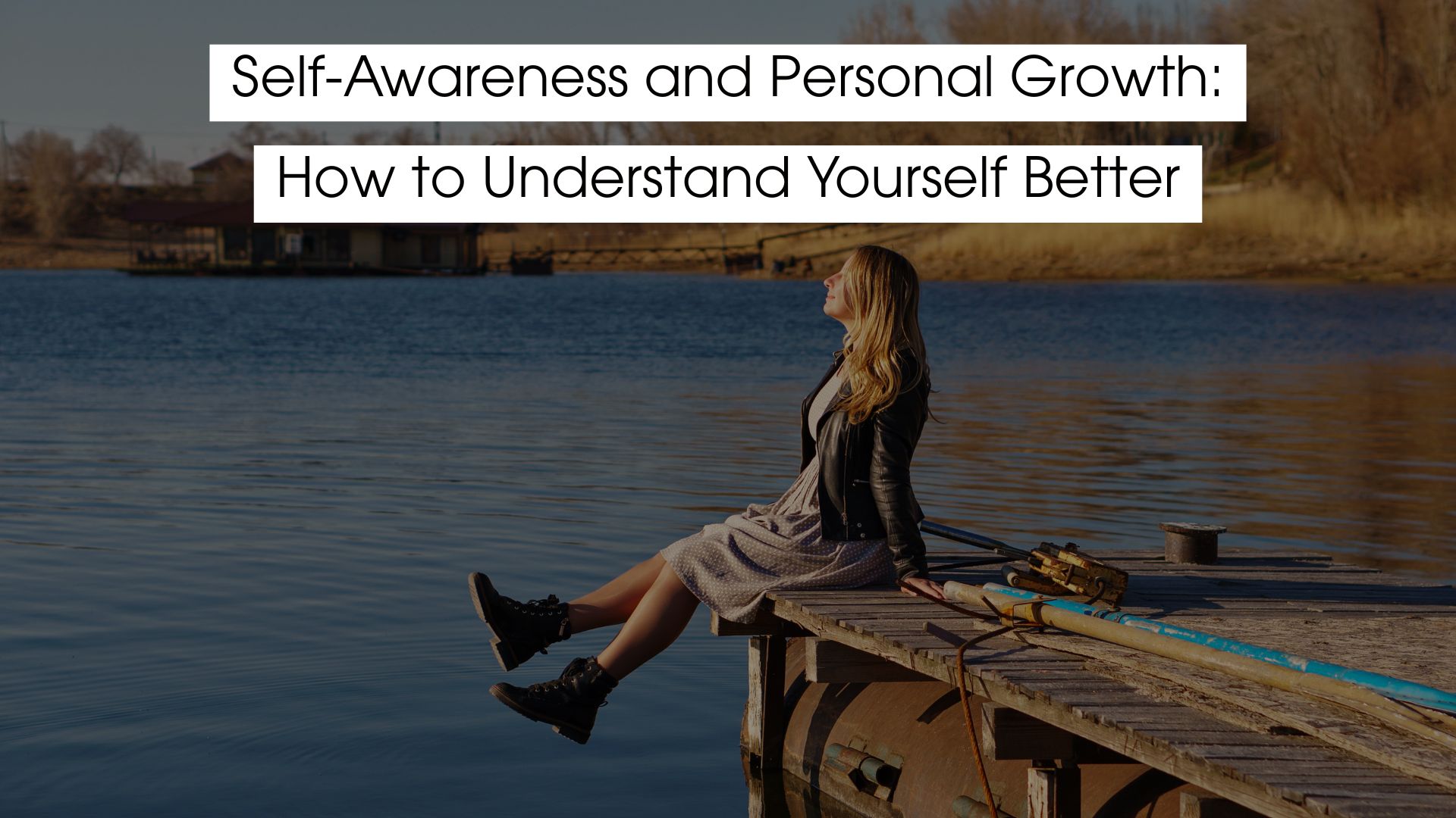 A woman sitting peacefully on a wooden dock by the water, reflecting quietly, symbolizing self-awareness and personal growth.