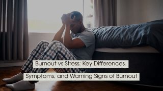 Man sitting on the floor beside a bed with his head in his hands, appearing overwhelmed or exhausted, with the text “Burnout vs Stress: Key Differences, Symptoms, and Warning Signs of Burnout” displayed across the image.