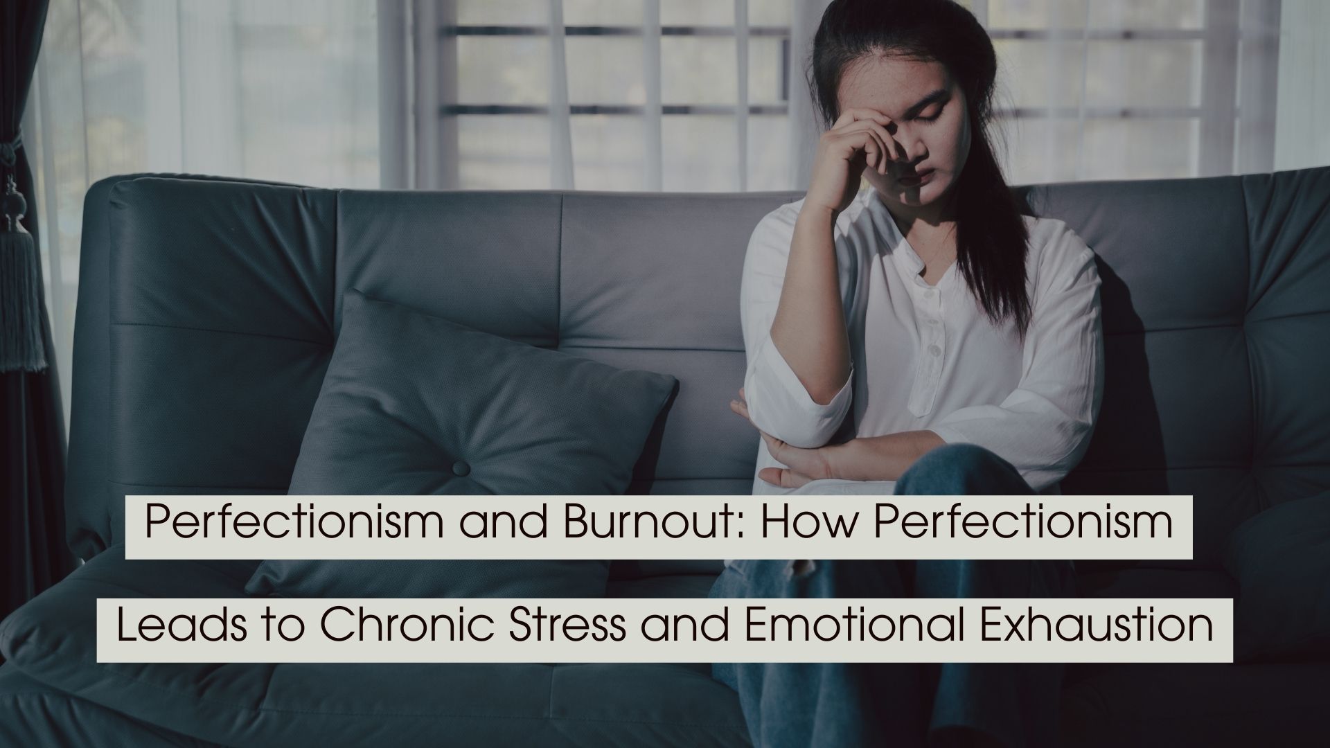 Woman sitting on a couch with her hand on her forehead looking overwhelmed and emotionally drained, with the text “Perfectionism and Burnout: How Perfectionism Leads to Chronic Stress and Emotional Exhaustion” displayed across the image.